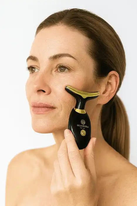 Frau verwendet schwarzen elektrischen Gesichtsstraffer für straffe Haut und jugendlichen Glow