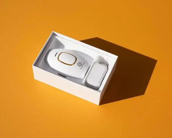 Glamora Beauty IPL Haarentfernungsgerät in Verpackung auf orangem Hintergrund